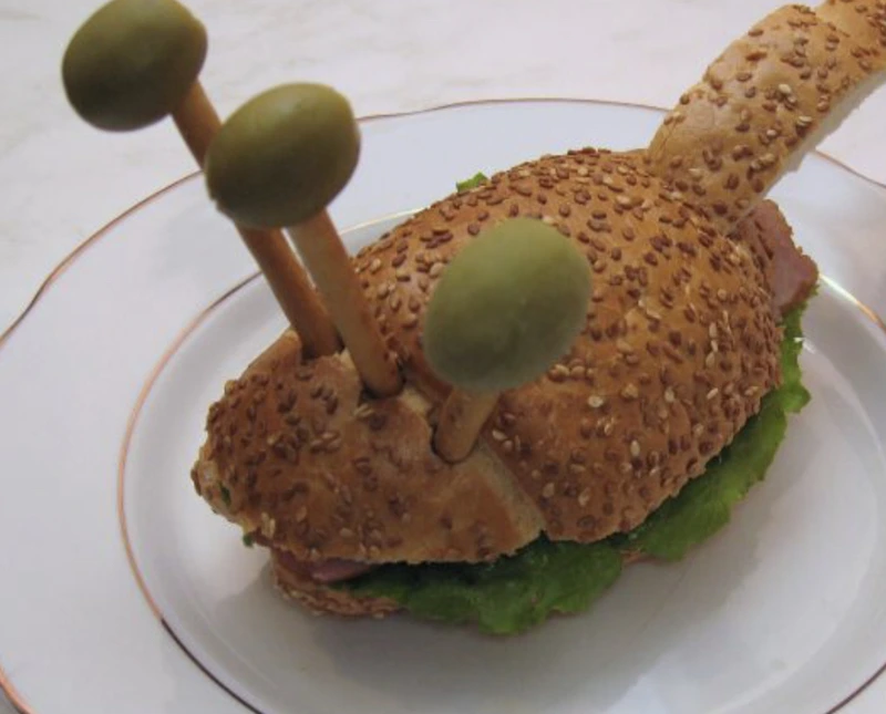 Put olives ("heads") on straws ("necks") and insert them into the "torso"