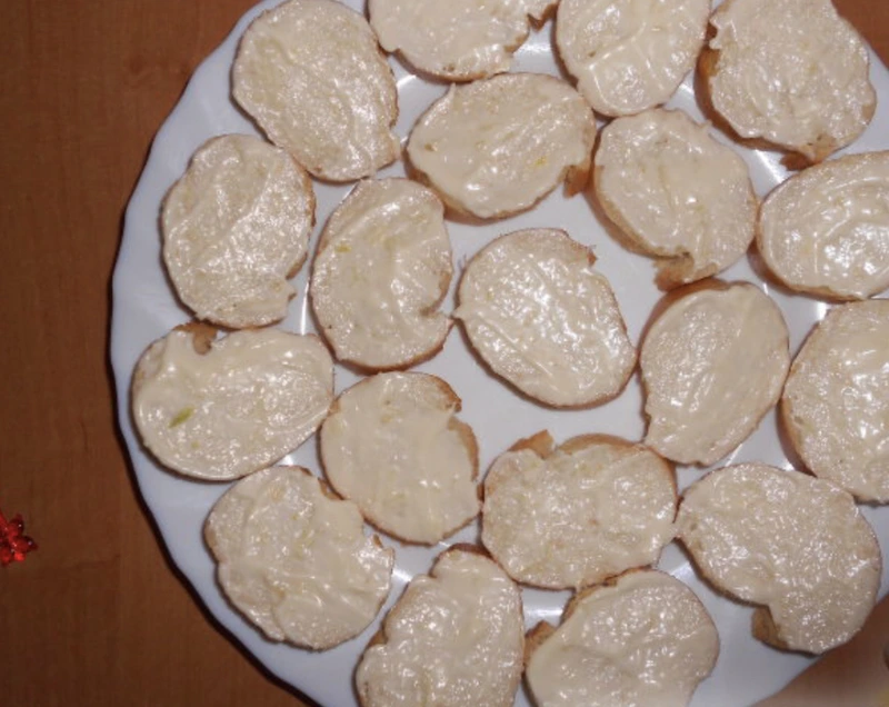 Spread the mixture of mayonnaise and grated garlic on each bread slice