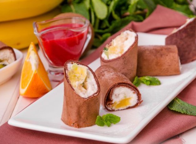 Rolls of Chocolate Pancakes With Cottage Cheese and Fruits