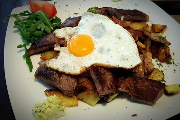 Fried Egg on Fried Potatoes with Schnitzel Strips, Onions and Herb Dip